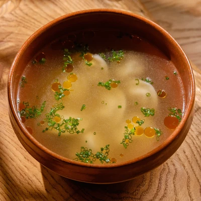 Бульон с пельменями, масло аджики, зелень